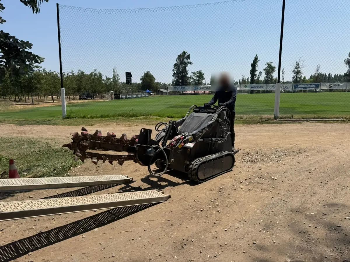 Operario trabajando en cancha de fútbol